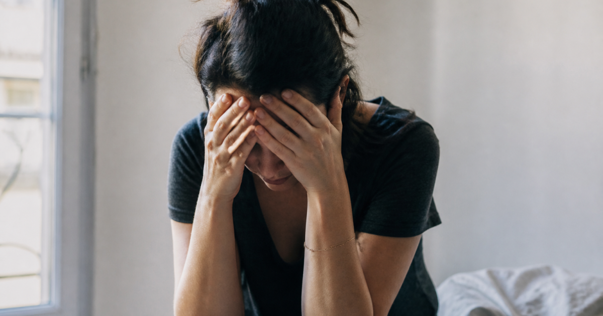 Femme tenant sa tête entre ses mains, épuisée