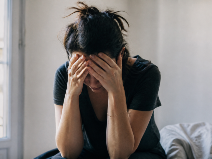 Femme tenant sa tête entre ses mains, épuisée