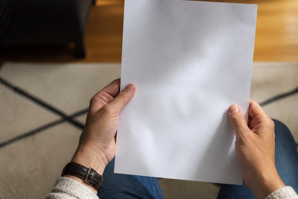 Mains tenant un papier blanc listant des signes d'alerte medicaux
