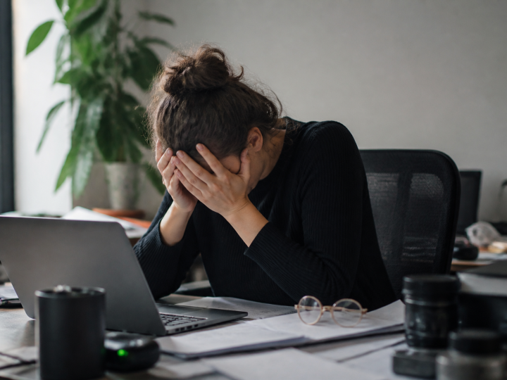 Personne epuisee assise au bureau, tete dans les mains