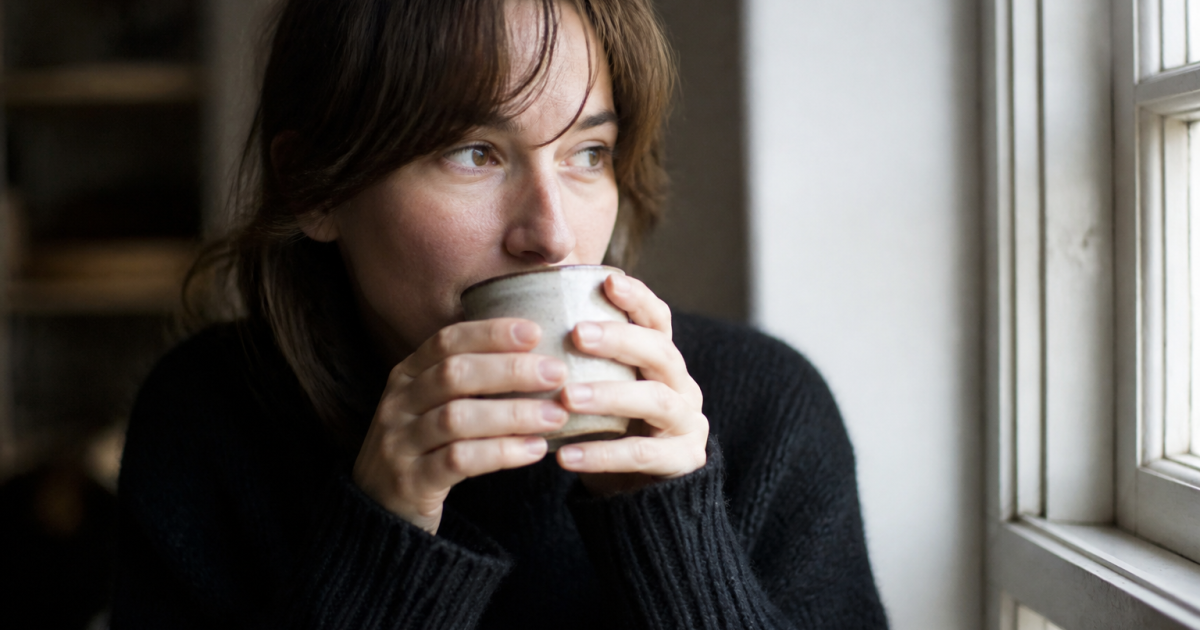 Femme tenant une tasse chaude près du visage