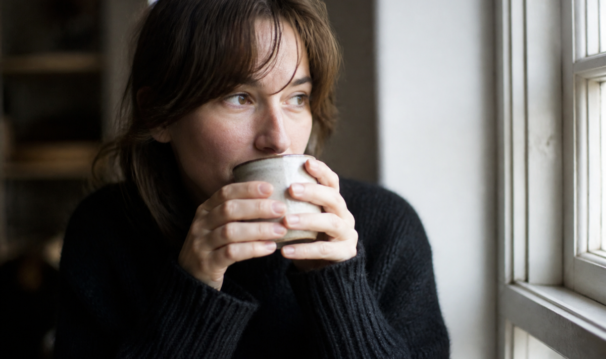 Femme tenant une tasse chaude près du visage