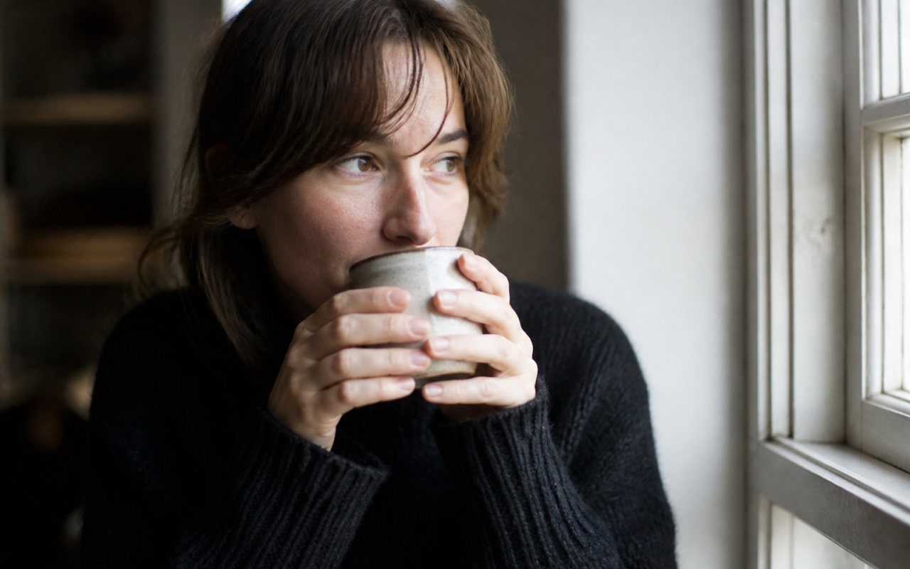 Femme tenant une tasse chaude près du visage