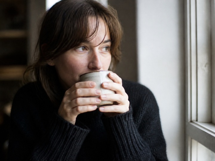 Femme tenant une tasse chaude près du visage