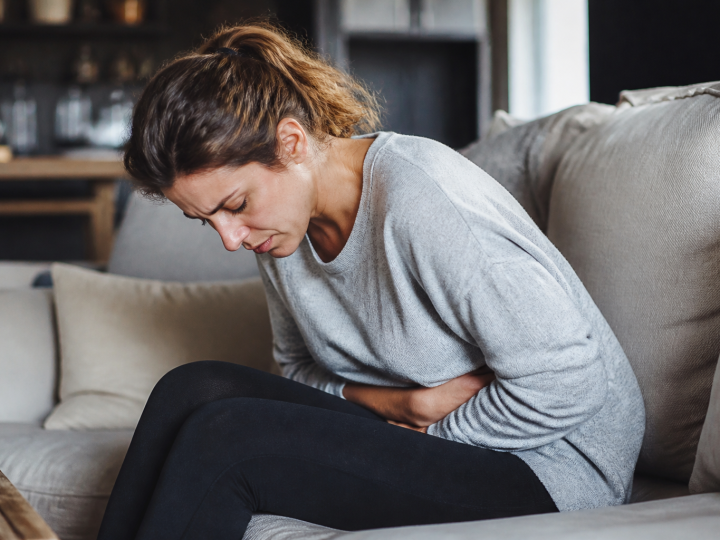 Femme assise tenant son bas-ventre en douleur