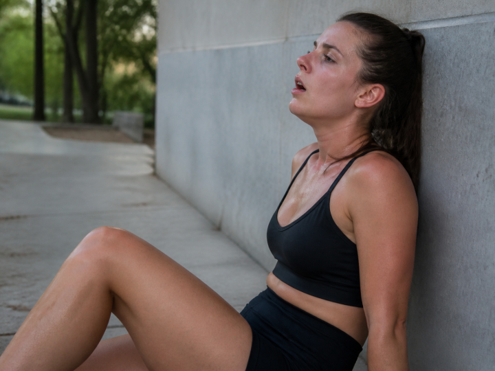 Femme assise appuyee contre mur respirant difficilement apres effort