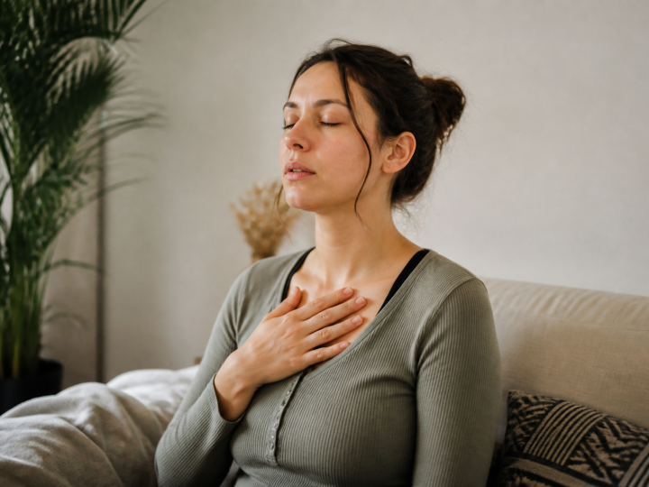 Femme assise respirant profondement main sur poitrine calme