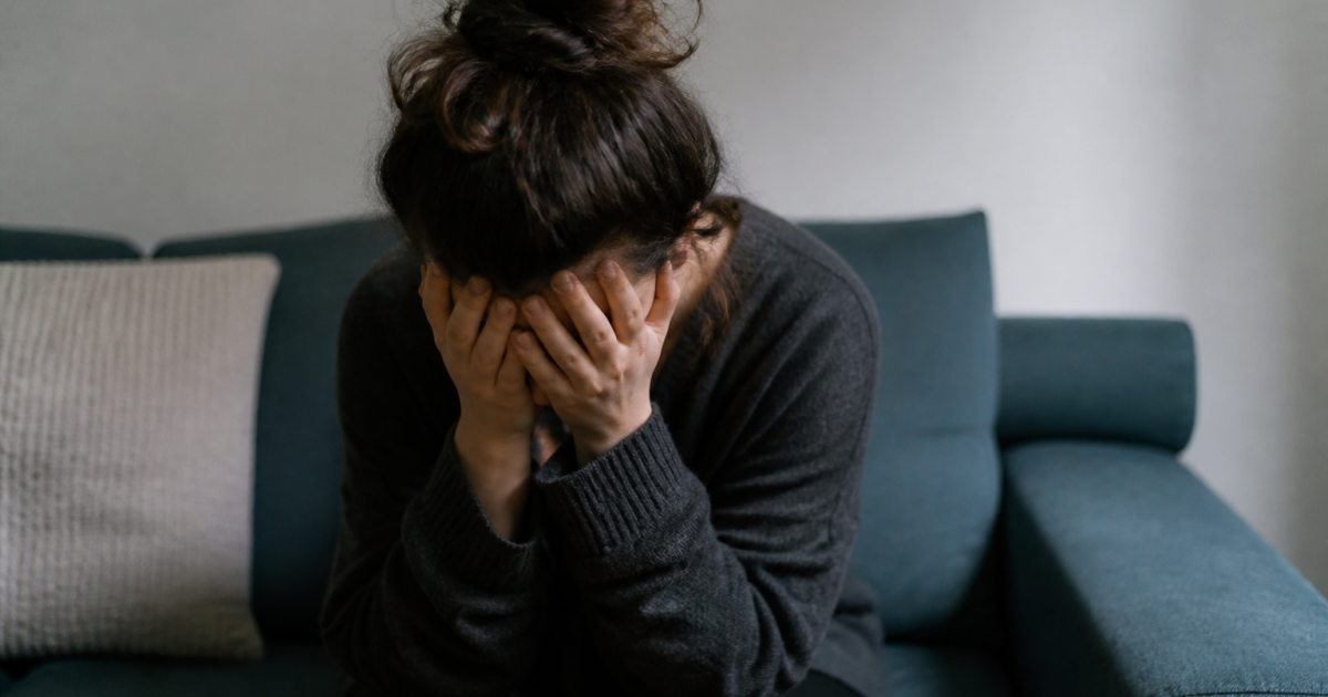 Personne assise tenant sa tete entre ses mains