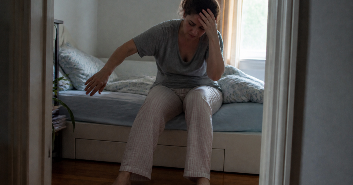 Personne se levant lentement du lit, main sur la tete, equilibre instable