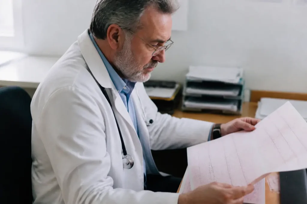 Medecin examinant un electrocardiogramme avec trace sur papier